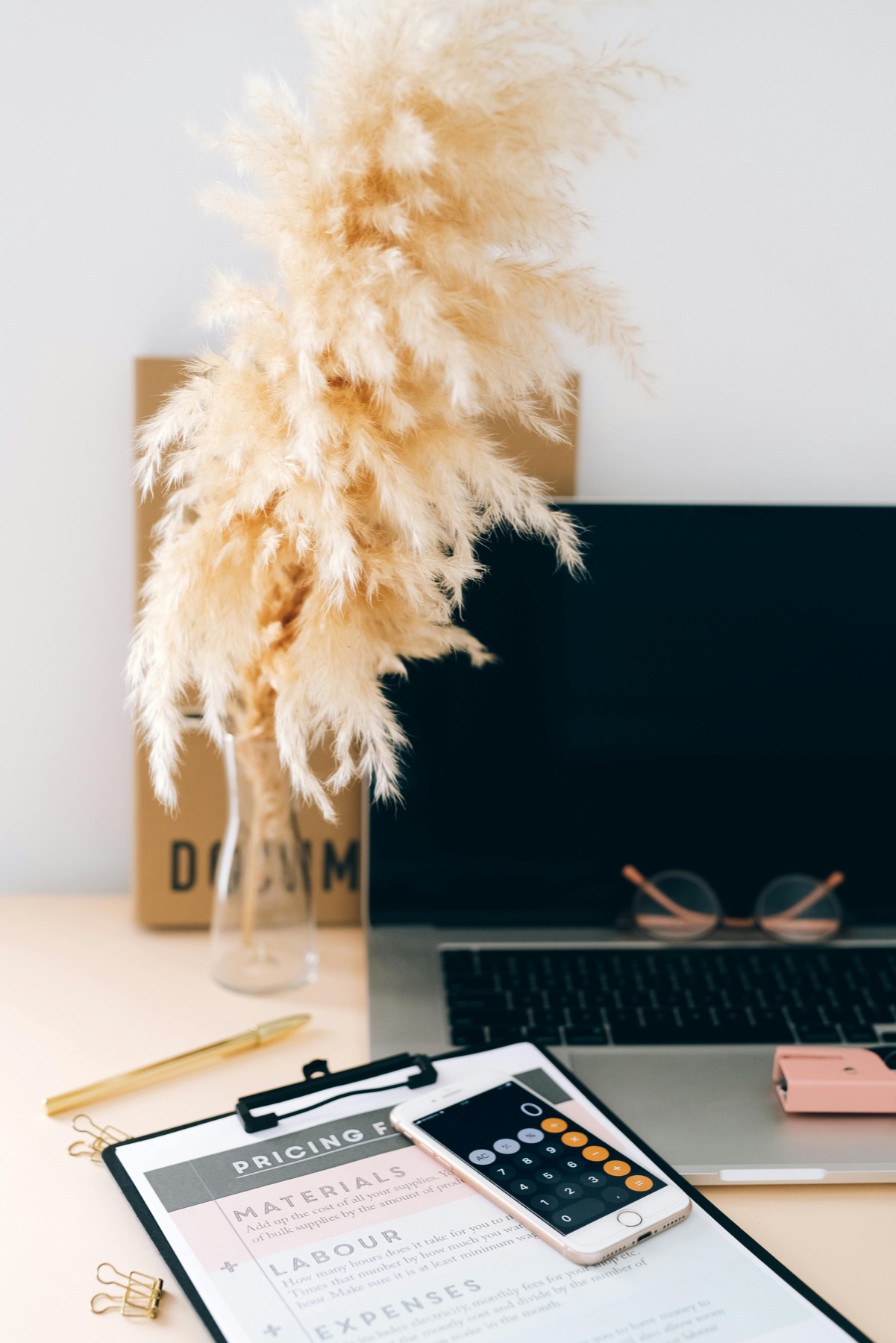 Bloc de facturation et calculatrice posés sur un bureau près d'un ordinateur